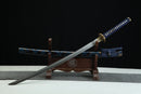 A blue and gold Japanese-style sword is displayed on a wooden stand against a black background.