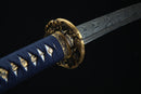 A close-up view of a decorative sword handle with intricate patterns and a gold-colored metal piece.