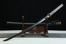 Sword on a wooden stand against a black background