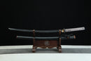 Sword on a wooden stand against a black background