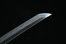 A close-up view of a Clay-Tempered San-Mai blade against a black background.