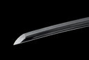 A close-up view of a clay-tempered Tamahagane steel blade against a black background