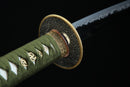A photo of a Kyojin Katana in green and white, with a gold and silver colored hilt, is shown against a black background.