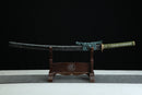 A close-up view of Kyojin Katana, with a green handle and black shealth on a wooden stand.
