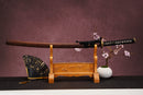 A close-up view of Moonswords Ghost of Kyoyu Katana, with a black handle and white accents, featuring intricate designs and patterns.