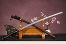 A close-up view of Moonswords Ghost of Kyoyu Katana, with a black handle and white accents, featuring intricate designs and patterns.