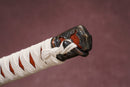 A single odachi with a white handle and orange accents on the stand is shown against a textured background.