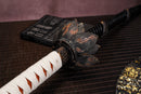 A photo of Moonswords Black mortal blade, Kaimon Odachi with an aged bronze guard, is shown against a dark background.