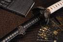 A close-up view of Moonswords Black Mortal Blade Odachi with bronze guard, white handle and black shealth.
