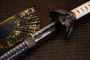 A close-up view of Moonswords Black Mortal Blade Odachi with black paint on the blade and intricate white and orange designs on the handle.