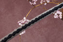 A close-up view of a Damascus steel blade against a textured background