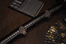 A close-up view of Moonswords Black Mortal Blade Odachi with bronze guard, white handle and black shealth.