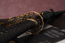 A photo of Moonswords Ryokuya Ichirin Katana in green, with a bronze guard, is shown against a dark, slatted bamboo mat background.