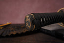 Close-up of Moonswords Ryokuya Ichirin katana handle with intricate designs on a textured surface.