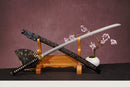 A close-up view of Moonswords Seima Guren Katana, with a black handle and white accents, featuring intricate designs and patterns.