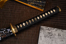 A close-up view of Moonswords Seima Guren Katana with bronze guard, black handle and black shealth.