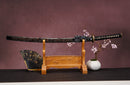 A close-up view of Moonswords Seima Guren Katana, with a black handle and white accents, featuring intricate designs and patterns.