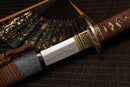 A close-up view of Moonswords Shunsho Katana with Hamon on the blade and intricate brown and gold designs on the handle.