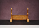 Wooden stand with carvings on a dark surface and purple background