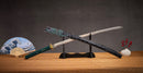 A close-up view of Moonswords Suiha Katana, with a green handle and black accents, featuring intricate designs and patterns.