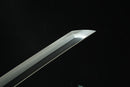 A close-up view of a Clay-tempered Tamahagane Steel blade against a dark background.