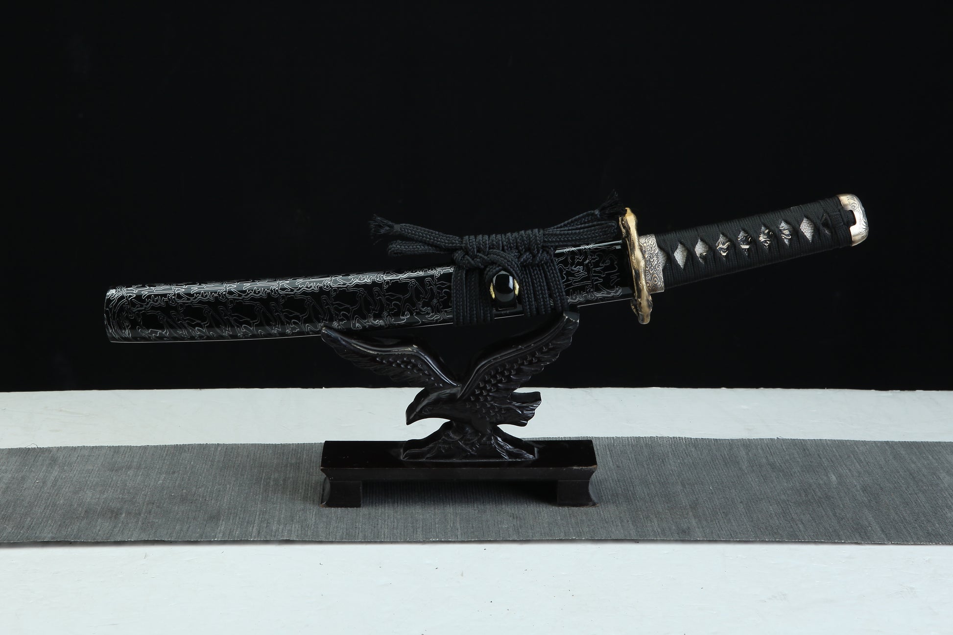 Black lacquered wooden saya with white pattern design of Tengyaku tanto featuring black cord wrapping and traditional finish
