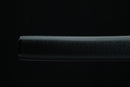 A close-up of a Japanese-style sword with a black handle and gold accents is displayed on a black surface, with a gray cloth underneath.