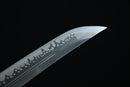 Blade of A Japanese-style sword with a black handle and gold accents is displayed on a black surface, with a gray cloth underneath.