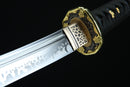A close-up view of a decorative sword blade with intricate patterns and a black handle.