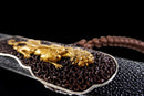 Close-up of the engraving on the black shealth of the Qianqing sword against a black background