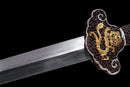 A closed up of the gold and silver guard of the Qianqing sword against a black background