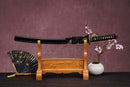 A single Wakizashi with a black handle and white accents on the stand is shown against a textured background.