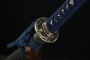 Sword hilt with blue cord and decorative elements on a dark background