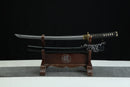 A traditional Japanese sword is displayed on a wooden stand against a black background.