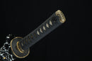 A close-up view of a black and gold sword handle against a black background.