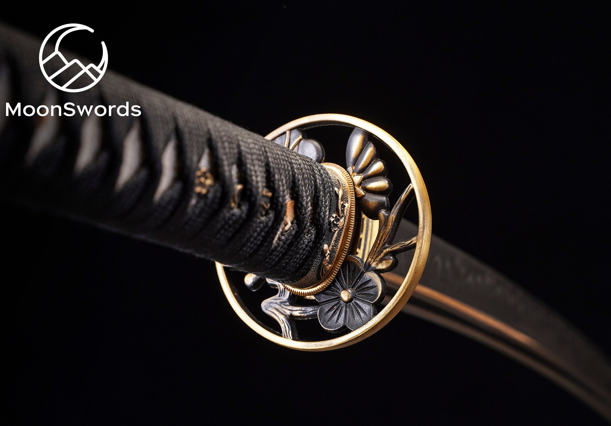 a close up of a black and gold colored sword