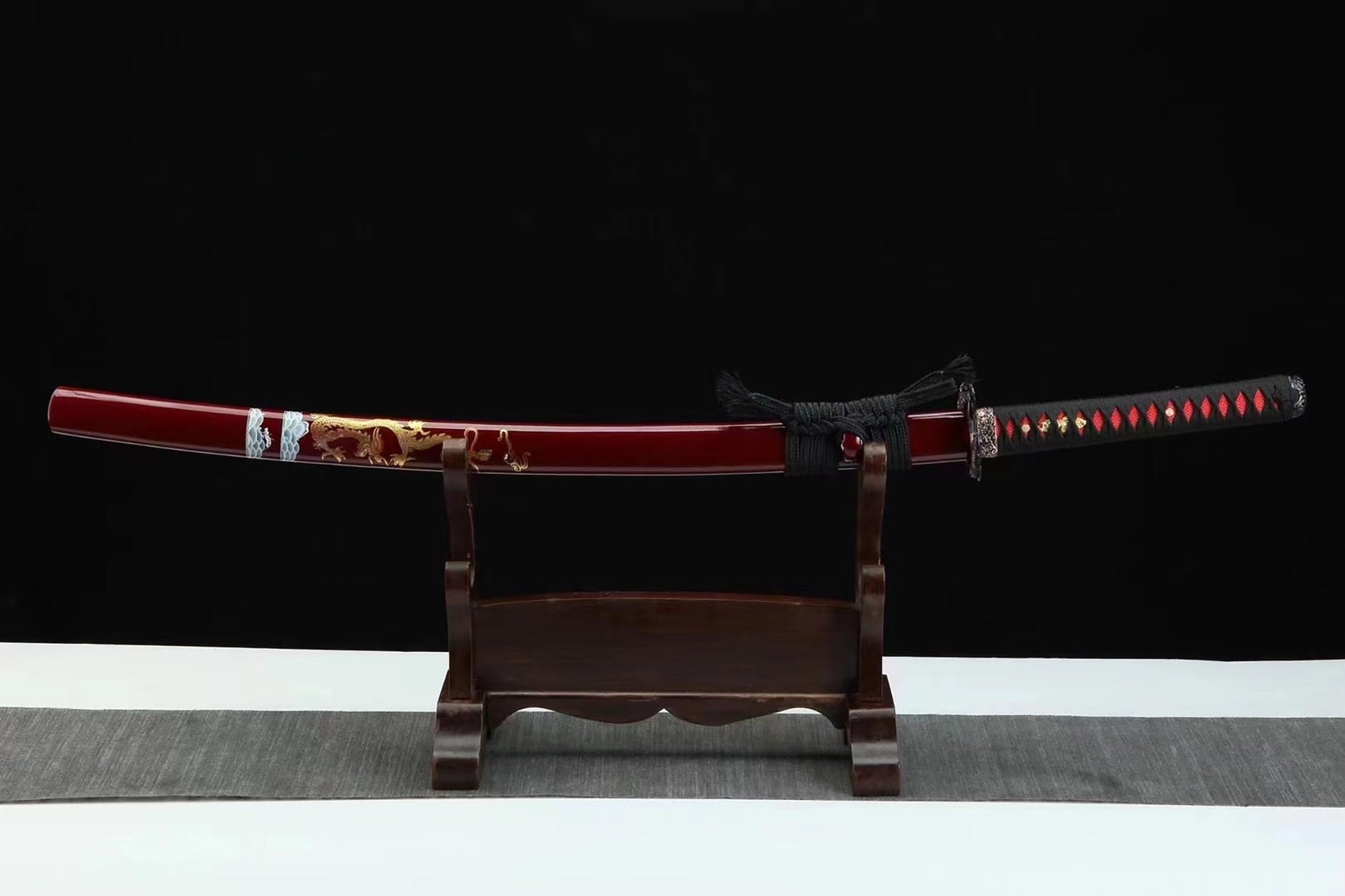 a wooden stand with a red and black sword on it